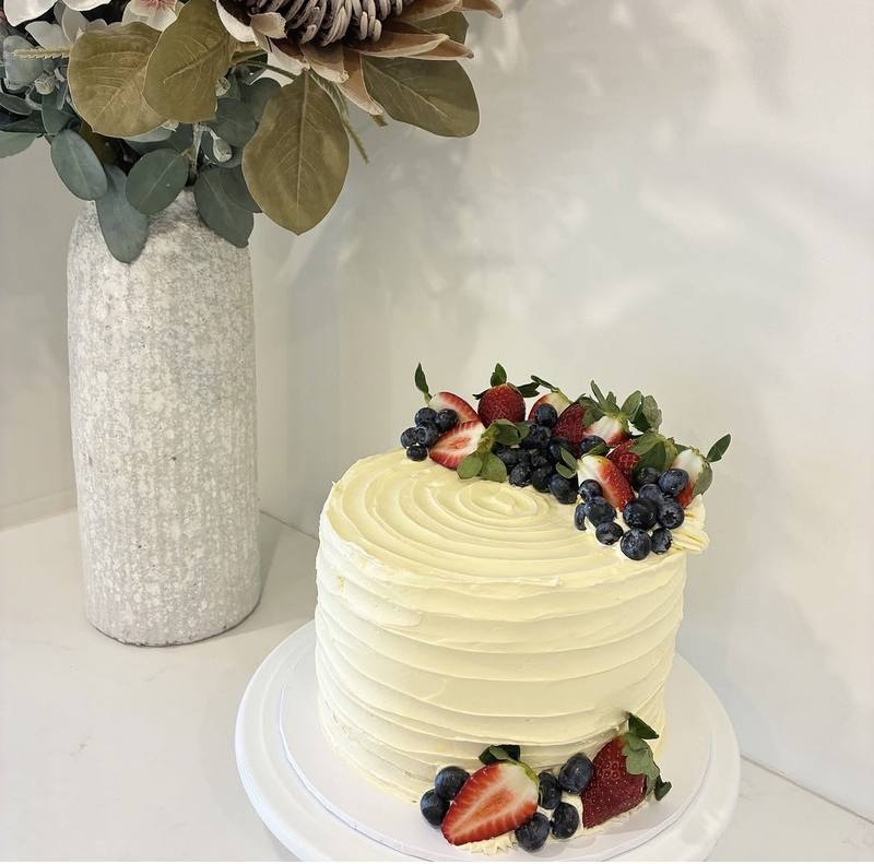 White wedding cake topped with fresh strawberries and blueberries