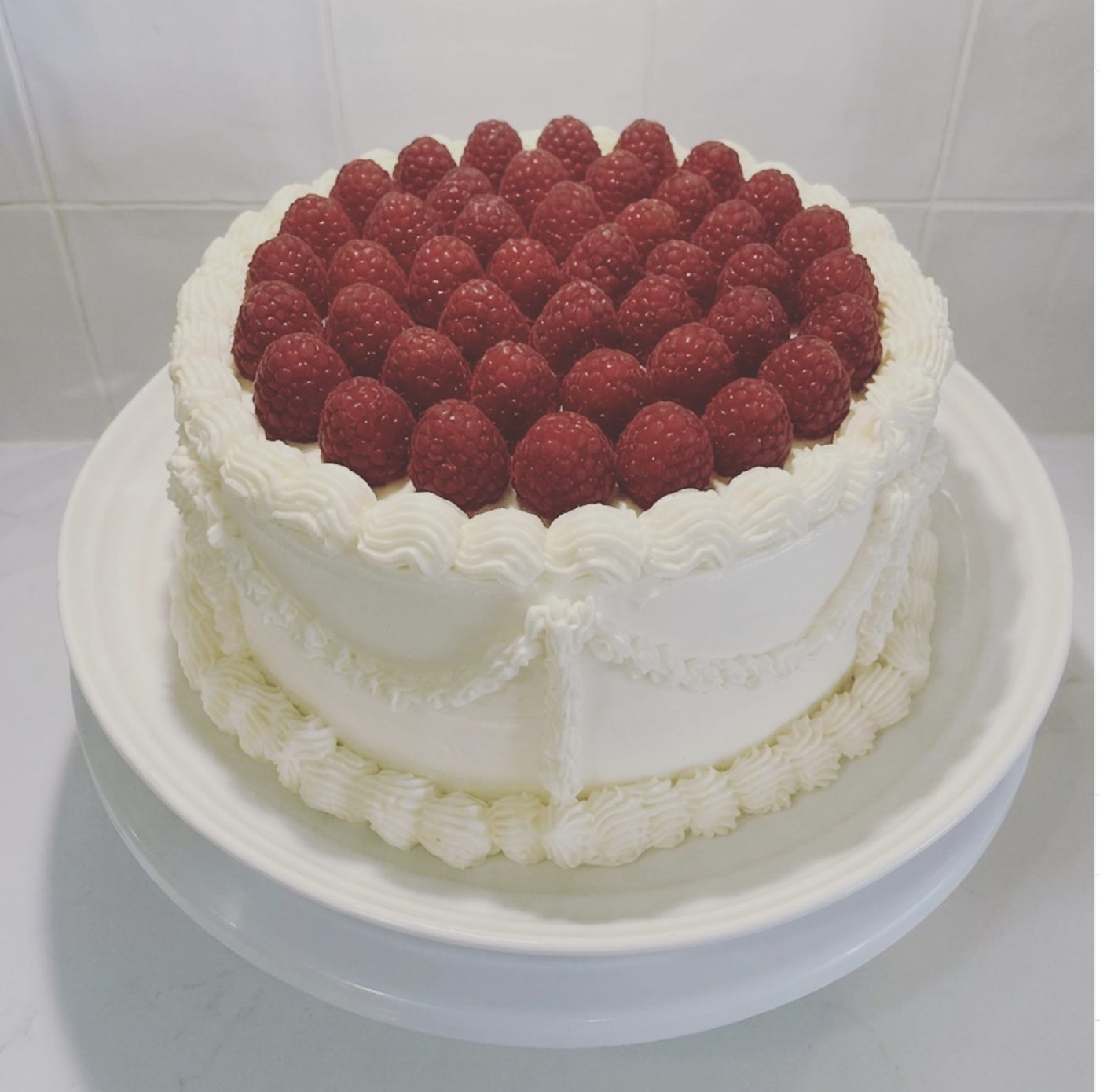 White buttercream wedding cake with fresh raspberries